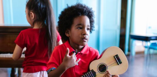 Jak wybrać pierwszy instrument dla dziecka – praktyczny przewodnik dla rodziców Dwoje dzieci gra na ukulele i pianinie w jasnym pokoju