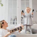 Mama i córka wspólnie grają na instrumentach w domu