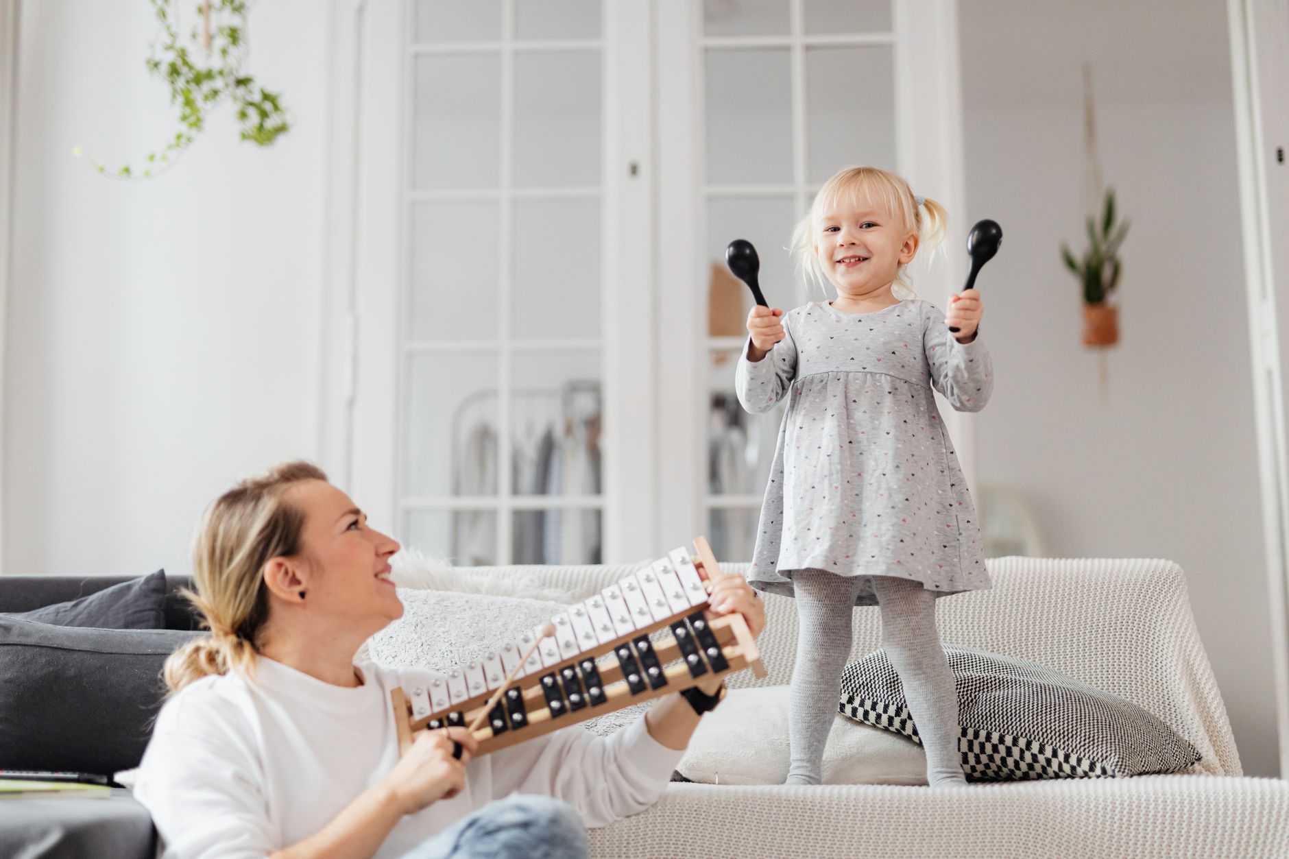 Mama i córka wspólnie grają na instrumentach w domu