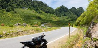 Motocykl na krętej górskiej drodze wśród zielonych wzgórz