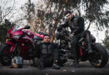 Motocyklowi bohaterowie anime i mangi, które musisz znać Dwóch motocyklistów w kombinezonach pozuje przy motocyklach na zewnątrz
