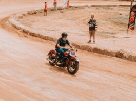 Legenda sportu wyścigowego jak dwusuwowe 250 i 500 przeorały świat motocykli torowych Klasyczny motocyklista pędzi po torze ziemnym podczas wyścigu