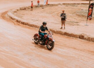 Legenda sportu wyścigowego jak dwusuwowe 250 i 500 przeorały świat motocykli torowych Klasyczny motocyklista pędzi po torze ziemnym podczas wyścigu