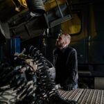 Mechanik ciężarówek ogląda silnik w warsztacie