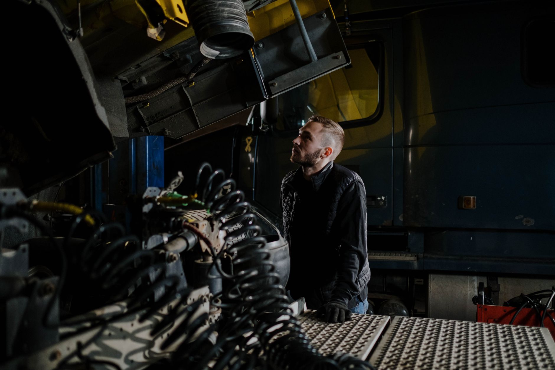 Mechanik w warsztacie sprawdza koło niebieskiej ciężarówki