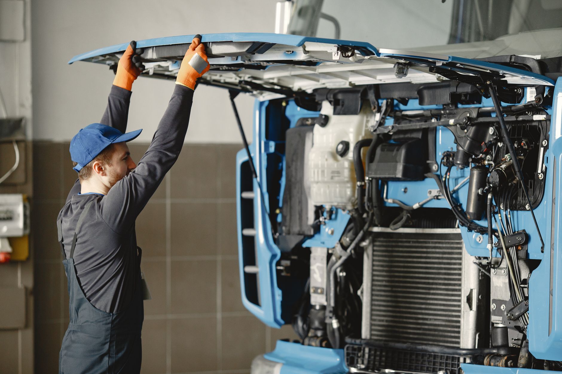 Mechanik w hali sprawdza silnik używanej ciężarówki z importu