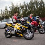 Motocykliści w pełnym stroju na parkingowym zlocie i rozmowie