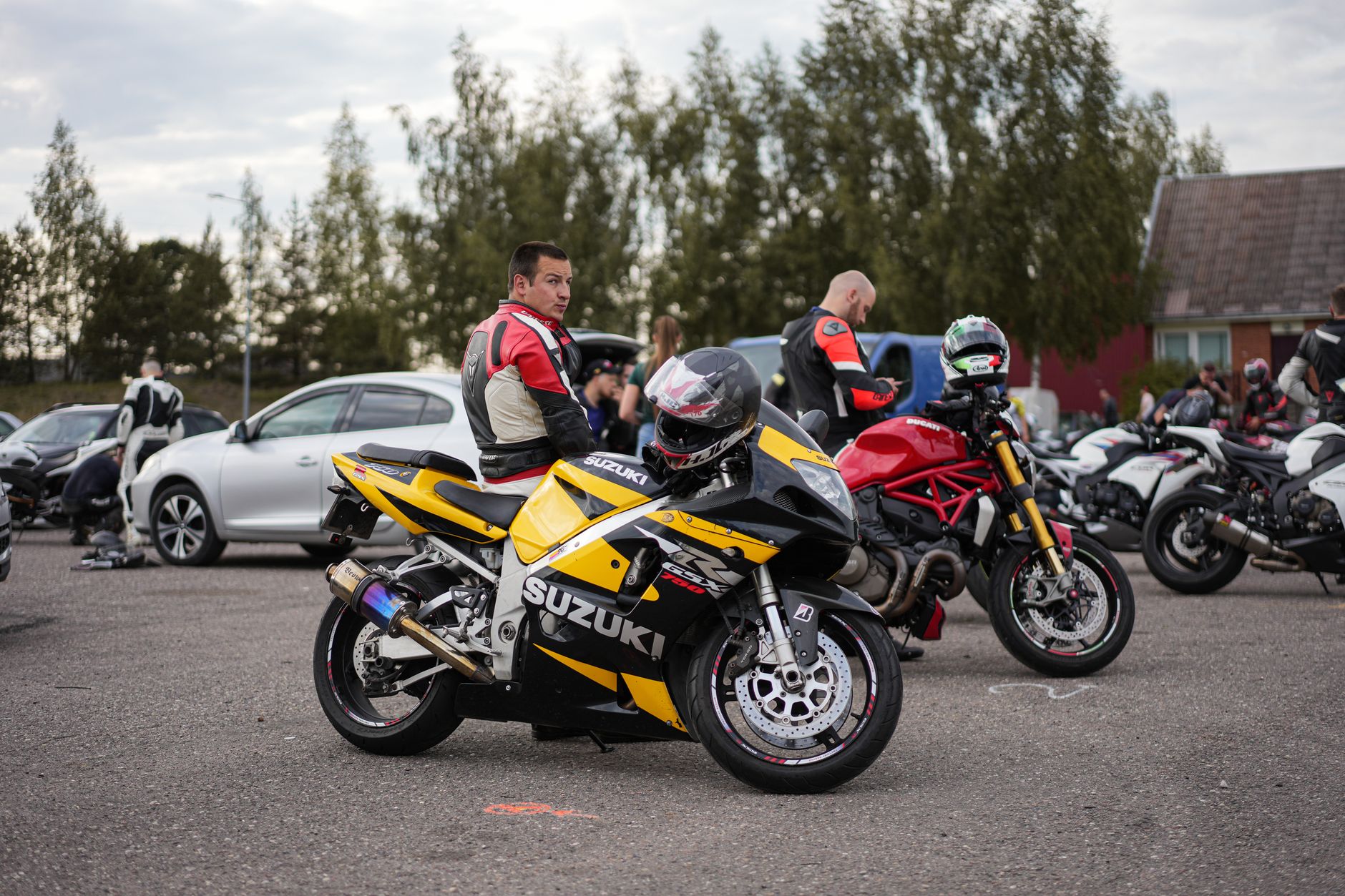 Motocykliści w pełnym stroju na parkingowym zlocie i rozmowie