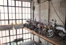 Czy każdy stary motocykl to klasyk jak odróżnić potencjalną ikonę od zwykłego starocia na złom Rząd retro motocykli na podestach w garażu przy dużych oknach