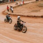 Zawodnicy ścigają się na zabytkowych motocyklach na torze ziemnym