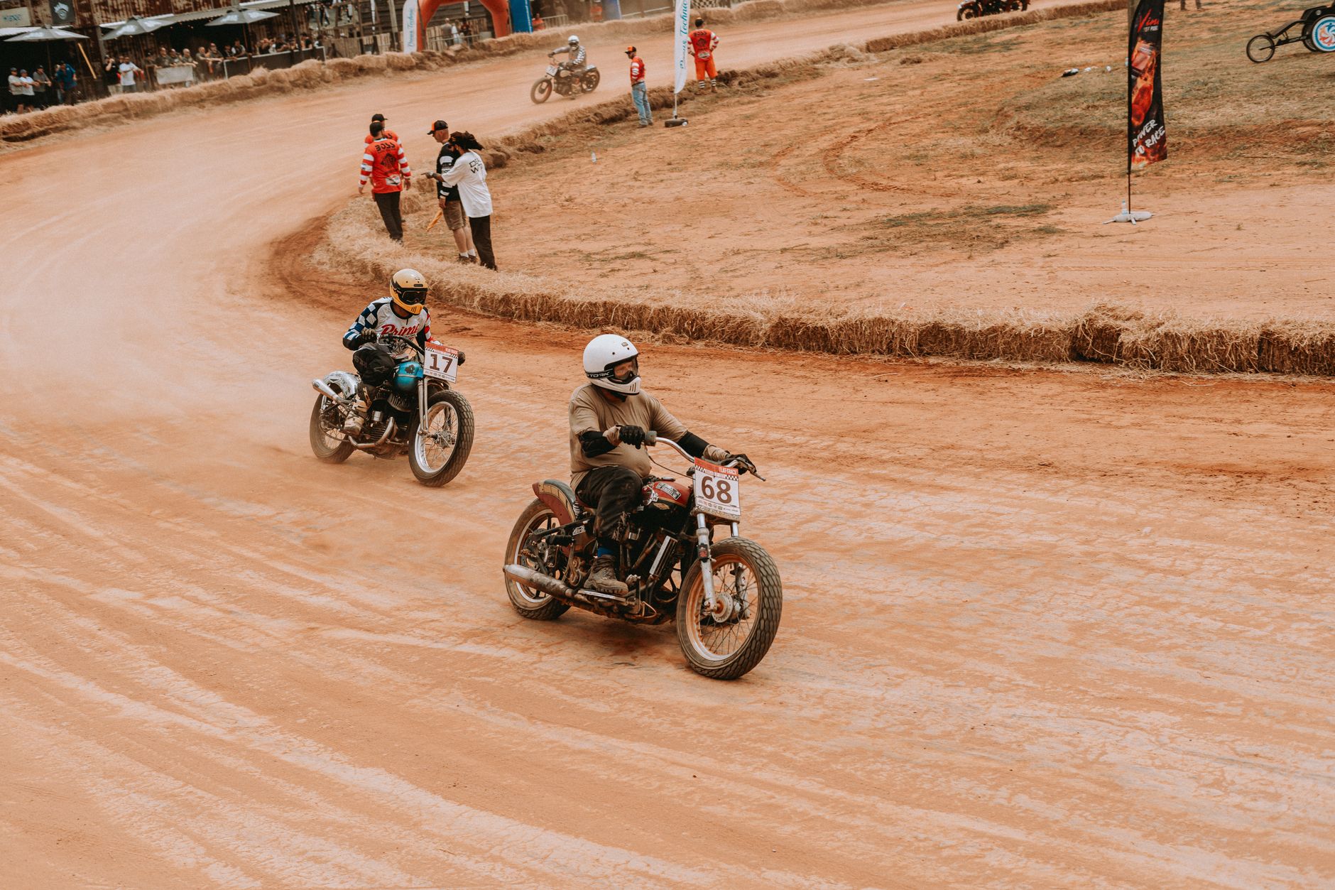 Zawodnicy ścigają się na zabytkowych motocyklach na torze ziemnym
