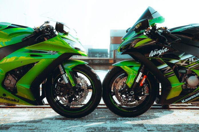 Dwa zielone motocykle Kawasaki Ninja ustawione obok siebie na zewnątrz Dwa zielone motocykle Kawasaki Ninja ustawione obok siebie na zewnątrz