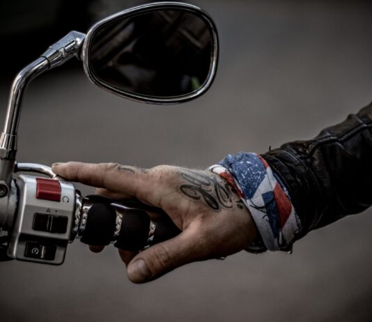 Gesty motocyklistów na drodze – co oznaczają znaki dłonią, nogą i kaskiem? Wytatuowana dłoń motocyklisty na