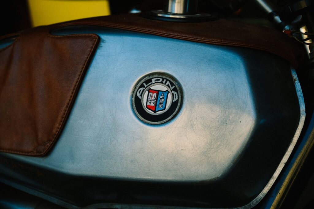 Zbliżenie logo Alpina na skórzanym baku motocykla